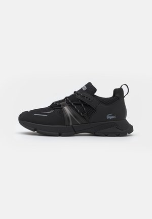 Baskets de sport noires avec tige en mesh et synthétique, design à lacets, languette à l’arrière et logo Lacoste sur le côté.