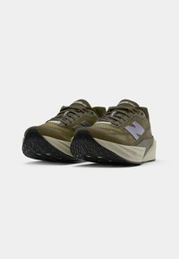 Zapatillas de running verde oliva con una parte superior de malla texturizada, acentos reflectantes y una suela de goma negra con un patrón de banda de rodadura detallado.