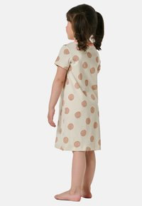 Abito per bambini a maniche corte color crema con un motivo a pois marrone chiaro ripetuto, con scollatura rotonda e tessuto morbido.