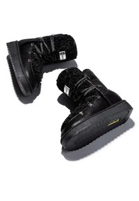 Botas de tobillo negras con parte superior de tejido texturizado, cierre de cordones y suela de goma. Las características notables incluyen ojales de metal y un tacón texturizado.