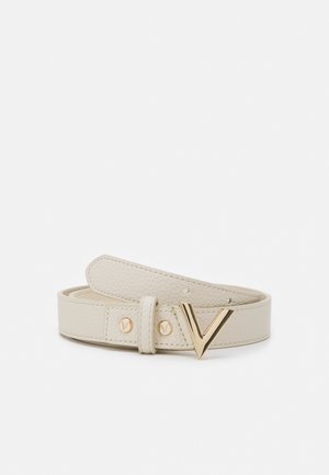 Ceinture en cuir texturé couleur crème avec boucle dorée en forme de V et rivets dorés assortis, enroulée sur fond blanc.