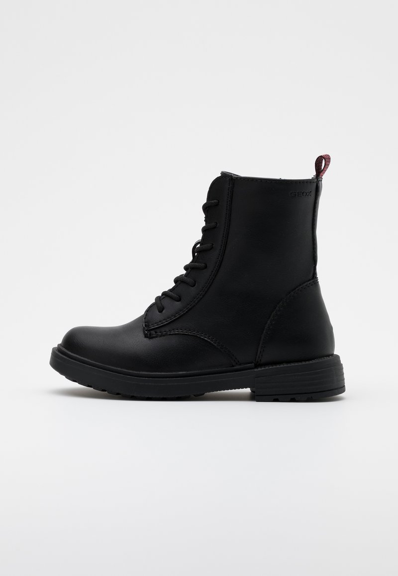 Bottines en cuir noir avec un laçage, bout rond, semelle texturée et une tirette rouge à l'arrière.