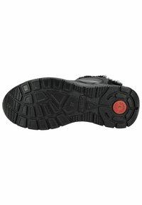Suela de bota de goma negra con un patrón de textura, que presenta un logo circular rojo y acentos rectangulares para tracción.