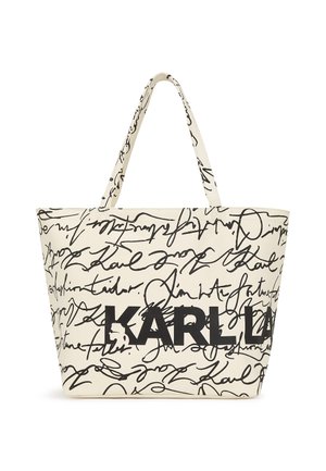 Sac fourre-tout en tissu beige avec un texte manuscrit noir et un logo "KARL" bien en vue. Le design comprend une forme structurée et spacieuse ainsi que deux poignées.