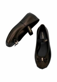 Bailarinas negras con una textura suave, que cuentan con un pequeño lazo de adorno y una correa ajustable. Fabricadas con un material flexible para mayor comodidad.