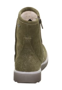 Grüne Wildleder-Ankle-Boots mit einem seitlichen Reißverschluss, weicher Fellfütterung und glitzerndem, strukturiertem Absatz. Mit einer weißen Gummisohle.