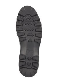 Gummisohle mit tiefen Rillen für Trittsicherheit, ausgestattet mit einer strukturierten Oberfläche und einem Logo, entwickelt für Langlebigkeit und Grip auf verschiedenen Untergründen.