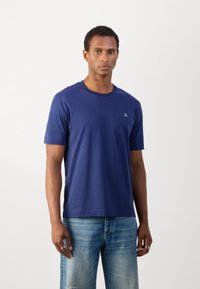 Marineblå bomulds T-shirt med korte ærmer, rund hals og en lille logoaccent på brystet. Glat tekstur, afslappet pasform.