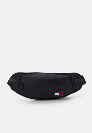 Sac banane Tommy Jeans noir avec sangle réglable et poche zippée à l'avant, arborant le patch logo de la marque.