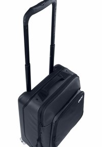 Borsa nera con ruote e manico telescopico, angoli rinforzati, scomparti con cerniera e esterno in tessuto resistente. Ruote lisce alla base.