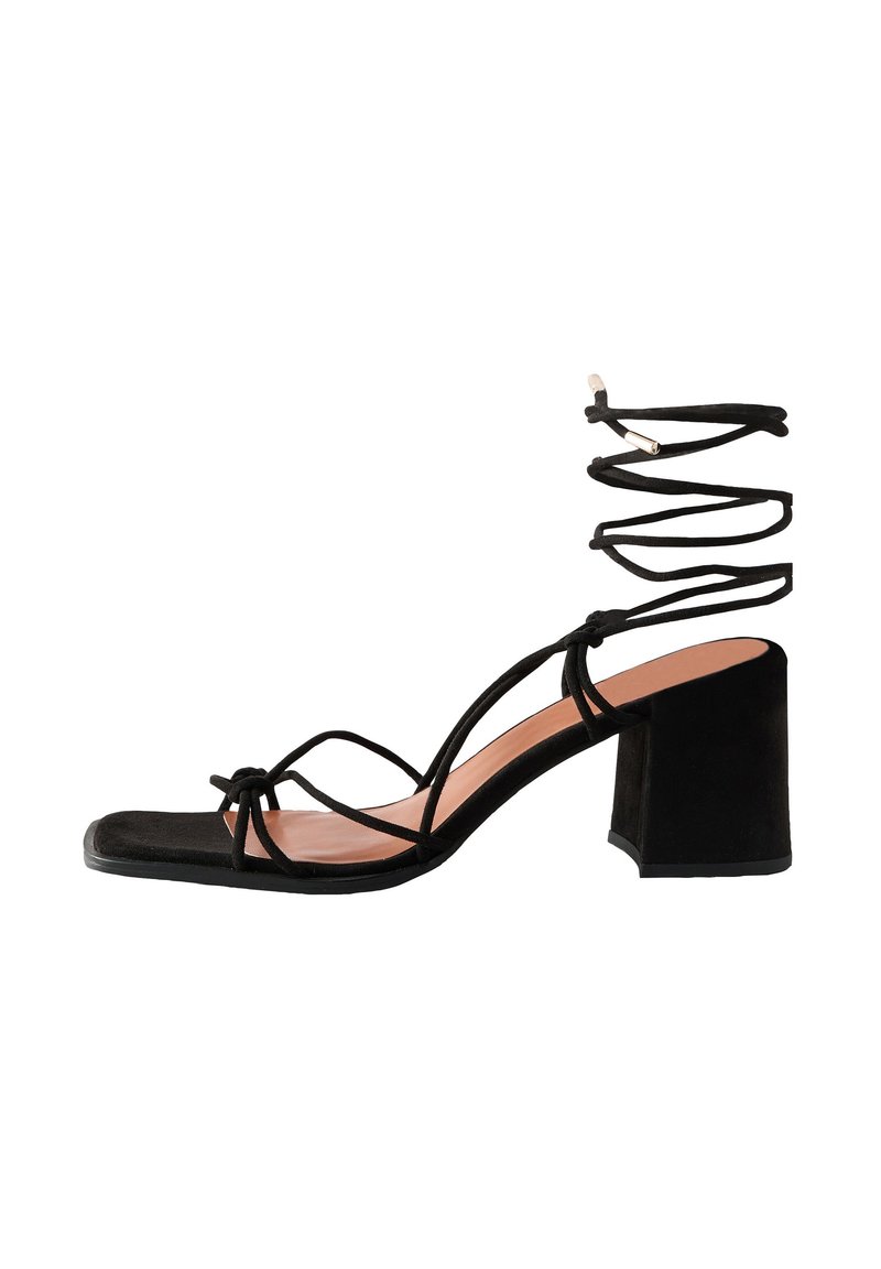Sandali con tacco in camoscio nero con punta quadrata, caratterizzati da sottili cinturini e design con fascetta alla caviglia, sostenuti da un tacco a blocco.