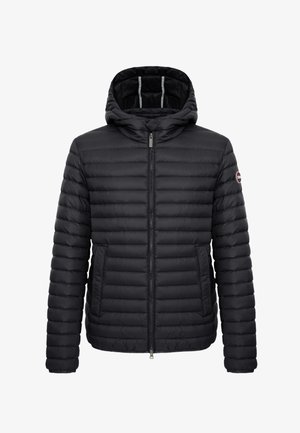 Chaqueta acolchada negra con capucha, cremallera frontal, bolsillos laterales y un pequeño logo circular en la manga izquierda.