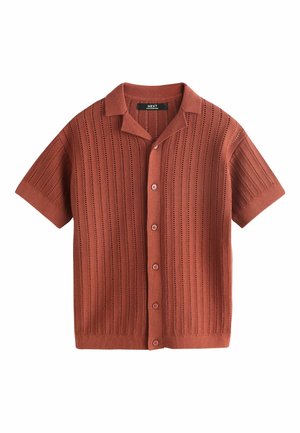 Kratký pletený top v hrdzavej farbe s vertikálnymi pruhmi otvorenej štruktúry, zapínaním na gombíky vpredu a rozšíreným golierom.