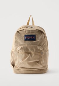 Μπεζ σακίδιο πλάτης Jansport από κορντόρι με εμπρόσθια τσέπη με φερμουάρ, δίχτυ πλαϊνή τσέπη και χειρολαβή στην κορυφή σε λευκό φόντο.
