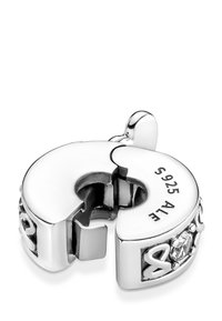 Charm de plata esterlina con diseño de cierre, que presenta un acento de piedra transparente, marcas grabadas y una superficie pulida.