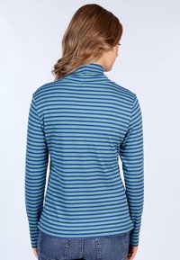 Langärmeliges Oberteil in grün-blauen Streifen, mit hohem Kragen und gerippter Textur. Das Material wirkt dehnbar und figurbetont, mit einem abgerundeten Saum.