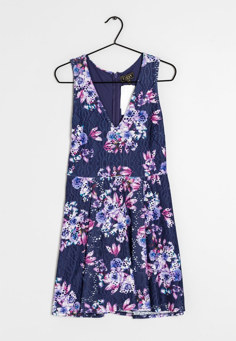 Kwiatowa, bezramiona sukienka z głębokim dekoltem w kształcie V, na granatowym tle, ozdobiona różowo-fioletowymi kwiatami. Posiada koronkową teksturę i rozkloszowany krój spódnicy.