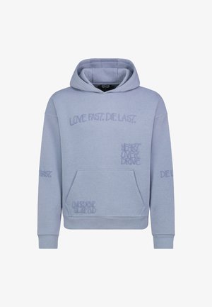 Hellblauer Kapuzenpullover aus Baumwollmischung, mit gestickten Phrasen: "LIEBE SCHNELL. STARBE LANGSAM." und "HERZ ÜBERDRIVE" in unterschiedlichen Schriftarten.