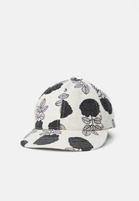 Cap with a black floral pattern on a light beige background, featuring a curved brim and textured fabric. Stitching accents enhance the design.
