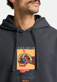 Gray hoodie with a front graphic featuring colorful, abstract artwork. Text reads "THE NEW YESTERDAY." Drawstring hood and soft texture.