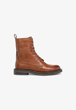 Bota de tornozelo em pele castanha com fecho de atacadores, acabamento liso, bico arredondado, salto bloco baixo e detalhe de costura nas laterais.