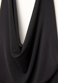 Tissu noir drapé avec une texture lisse et légère ; présente de profonds plis et un design fluide et ondulant, créant une apparence superposée.