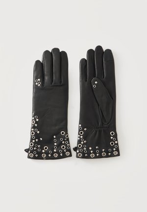 Coppia di guanti in pelle nera con decorazioni in metallo argentato vicino al polso su uno sfondo semplice.