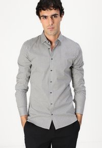 Camicia abbottonata in grigio chiaro con piccolo motivo geometrico e bottoni scuri. Maniche lunghe, vestibilità slim e un design del colletto rigido.