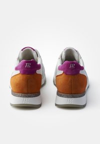 Sneaker in suede bianco e arancio con un tab sul tallone in suede viola, suola grigia con macchie e logo impresso sul tallone.