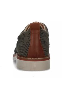Sneaker in rete verde con accento in pelle marrone al tallone, suola in gomma e dettagli cuciti. Il design presenta un pattern testurizzato.