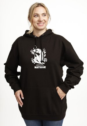 Schwarzer Kapuzenpulli mit einem großen weißen Grafikmotiv einer Figur, umgeben von Blättern, mit einer Vordertasche und einer Kordelzugkapuze.