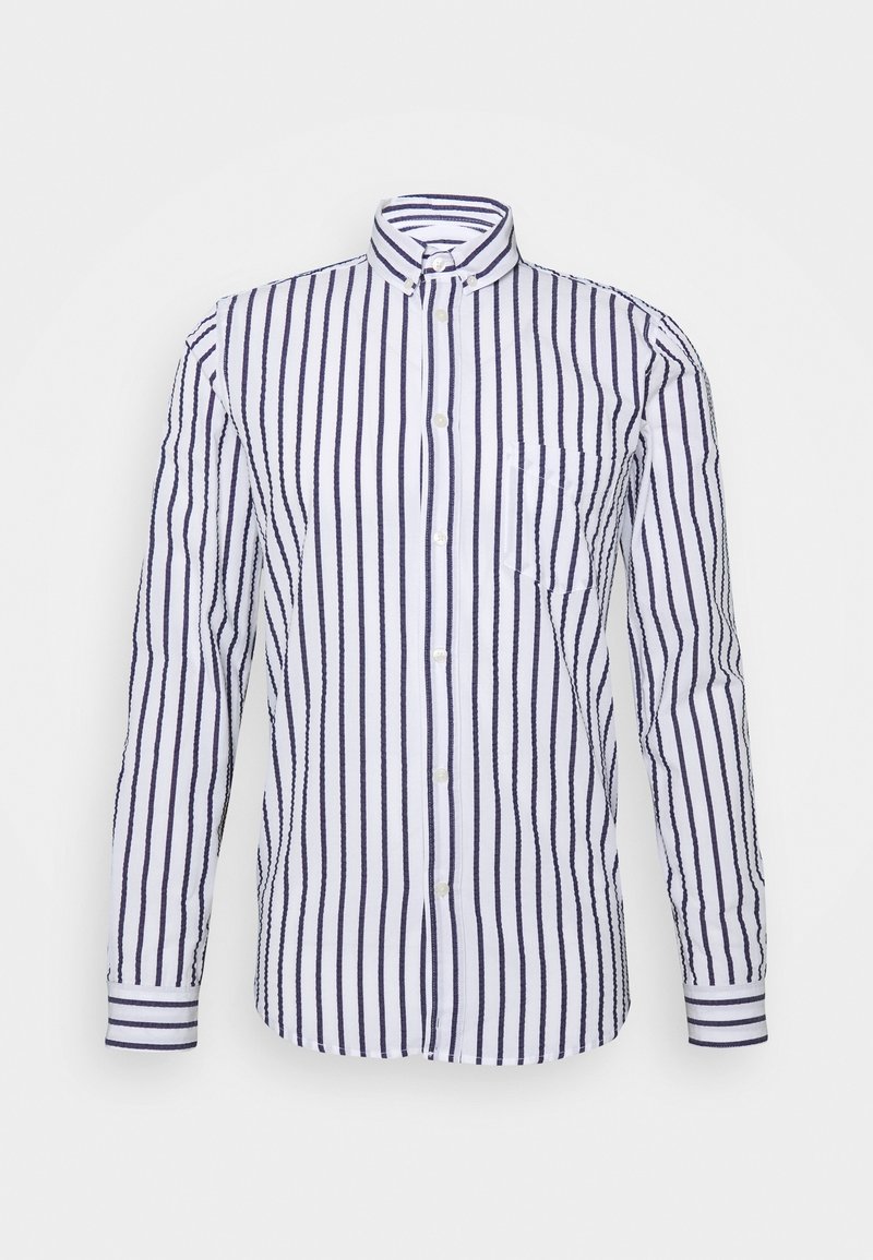 Weiße Hemd mit Knöpfen und marineblauen vertikalen Streifen, ausgestattet mit einem offenen Kragen und einer einzelnen Brusttasche. Lange Ärmel mit knöpfbaren Manschetten.