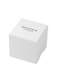 Vit pappkartong med "SKAGEN" och "DANMARK" tryckt i svart. Fyrkantig form med en slät, matt yta. Minimalistisk design.