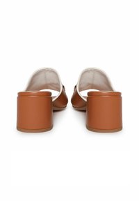 Mules marrones con tacón y parte superior de cuero suave. Diseño de punta redondeada y tacón de bloque grueso. Interior forrado con una tela beige.