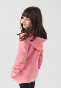 Felpa con cappuccio rosa con coulisse, maniche lunghe e tasche frontali. Tessuto liscio con polsini e orlo a coste. Leggings neri.