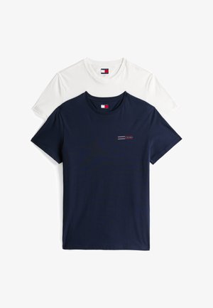 Due magliette impilate; una blu navy, l'altra bianca. Entrambe hanno un collo rotondo e maniche corte con un piccolo dettaglio del logo sulla maglietta blu.