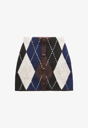 Skrót z dzianiny z wzorem w argyle w kolorach niebieskim, czarnym, białym i brązowym. Z przodu znajduje się pięć brązowych guzików z białymi stichami.
