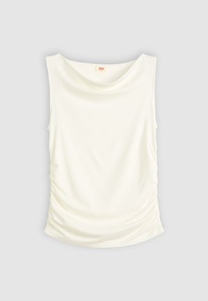 Bela brezrokavnik s spuščeno ovratnikom in gubami na straneh, prikazan na enostavni svetlo sivi ozadju.