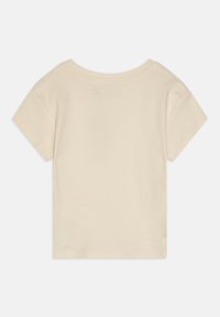 T-shirt corto a maniche corte beige chiaro con scollatura rotonda, realizzato in morbido tessuto di cotone. Presenta una texture semplice e liscia.