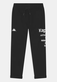 Zwarte joggingsbroek met elastische tailleband en trekkoord, wit logo op de linkerdij, en gedeeltelijke witte tekst op de rechterdij.