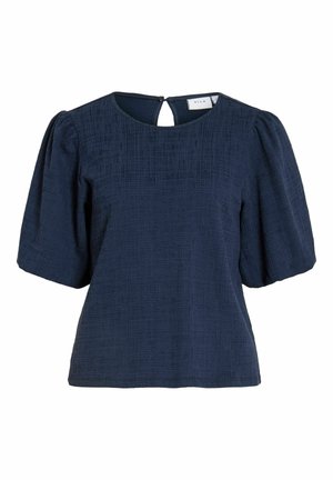 Blouse en tissu texturé bleu marine avec manches courtes bouffantes, encolure ronde et fermeture dos à bouton avec ouverture en forme de goutte.