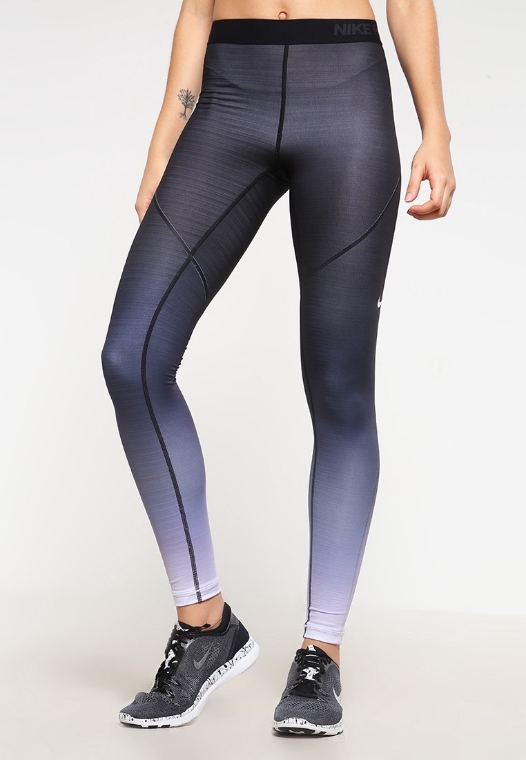 Mallas de Nike con un degradado que va del azul marino oscuro al gris claro, hechas de un material suave y elástico, con una cintura alta y costuras planas.