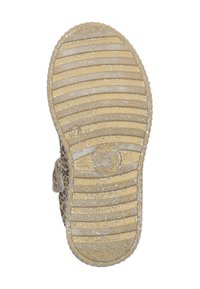 Beige Außensohle mit einem strukturierten Muster aus horizontalen und vertikalen Rillen, versehen mit einem dezenten glitzernden Akzent und einem runden Brandingdetail.