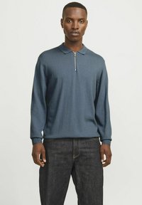 Dunkelblauer Pullover mit Kragen und Reißverschluss. Hergestellt aus einem strukturierten Strickstoff. Schlanker Schnitt mit langen Ärmeln und gerippten Bündchen.