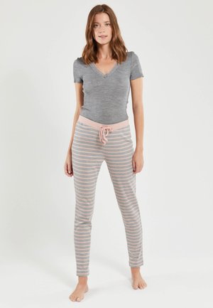 Haut gris à manches courtes et décolleté en V associé à un pantalon de jogging à rayures rose clair avec cordon de serrage. Tissu doux avec une coupe décontractée.