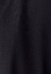 Mustast kangast, mis näitab veidi tekstureeritud pinda, matipinnaga ja peene kudumismustriga, mis viitab kergele materjalile.