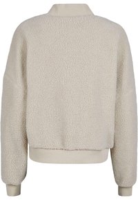 Pull en polaire beige avec une surface texturée et duveteuse, des poignets côtelés et un col. Présente une coupe décontractée et un ourlet cropped.