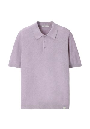 Polo violet clair à manches courtes, avec une patte à trois boutons et une petite étiquette blanche sur l'ourlet inférieur.