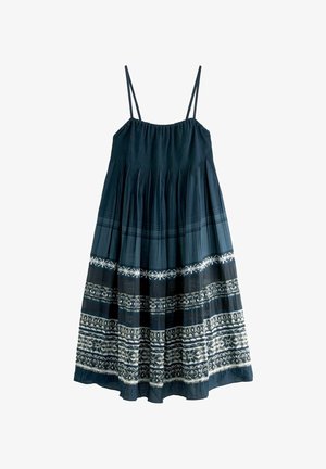 Robe bleu marine sans manches avec fines bretelles et motifs floraux et géométriques blancs complexes près de l'ourlet.