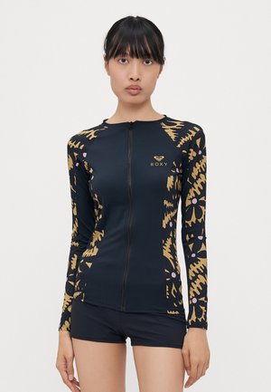 Roxy langermet badetopp i marineblå med glidelås foran. Har et gull- og beige abstrakt mønster, tettsittende design og mykt, elastisk stoff.